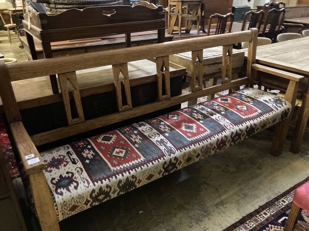 A 19th century Continental oak bench settle, with kelim upholstered seat, width 200cm depth 48cm height 104cm